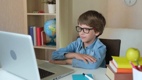 Online distance education learning lesson concept. Child Boy Kid schoolboy in glasses using tablet laptop computer for school homework, studying at home. Coronavirus COVID-19 quarantine, 4 K slow-mo