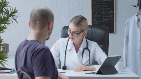 A friendly doctor sees the patient and starts a consultation with them in a bright and modern medical office