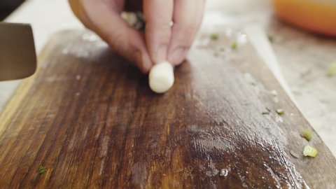 Slicing and chopping onion on a wooden board with special knife defocused. High quality 4k footage