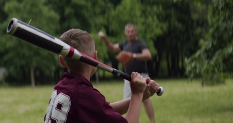 MED Father and son playing baseball in the park on a rainy day. Family time spent together. Shot with 2x Anamorphic lens