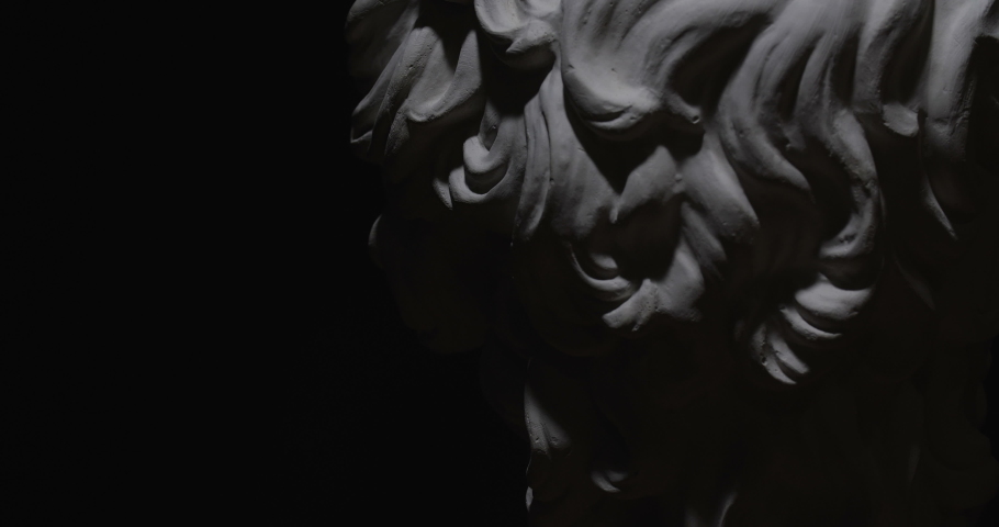 Epic studio close up detail shot. Rotating Antinous gypsum head with moving and changing lighting. The play of light and shadow on half face of statue of man. On black background isolated 4k Royalty-Free Stock Footage #1054402193