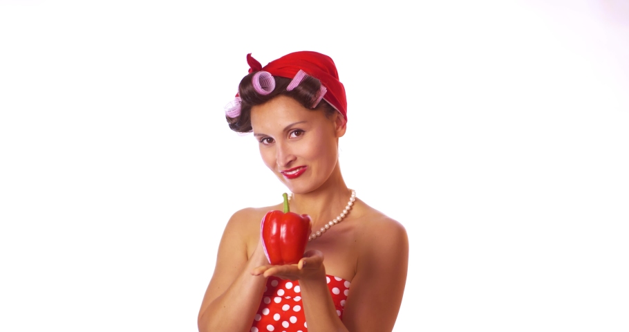 Funny housewife in pin up style with redbell pepper. Isolated on white background. Whole foods, vegan or vegeterian food.