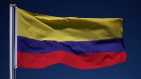 Colombia Flag flying in the wind outdoors with Blue sky behind - Colombian flag on flagpole.  Stock 4K Video Clip Footage