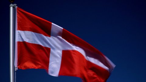 Denmark Flag flying in the wind outdoors with Blue sky behind - Danish flag on flagpole.  Stock 4K Video Clip Footage
