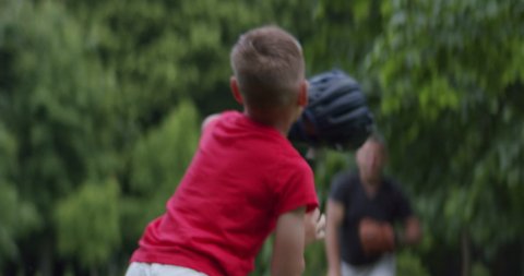 MED Father and son playing baseball catch in the park on a rainy day. Family time spent together. Shot with 2x Anamorphic lens