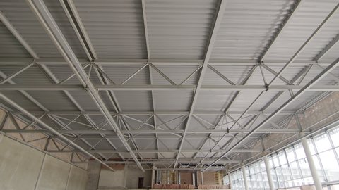 Ceiling of metal construction of a large modern room. Panorama of iron modern ceiling structures of a large restaurant. Modern storehouse construction site, structural steel structure commercial