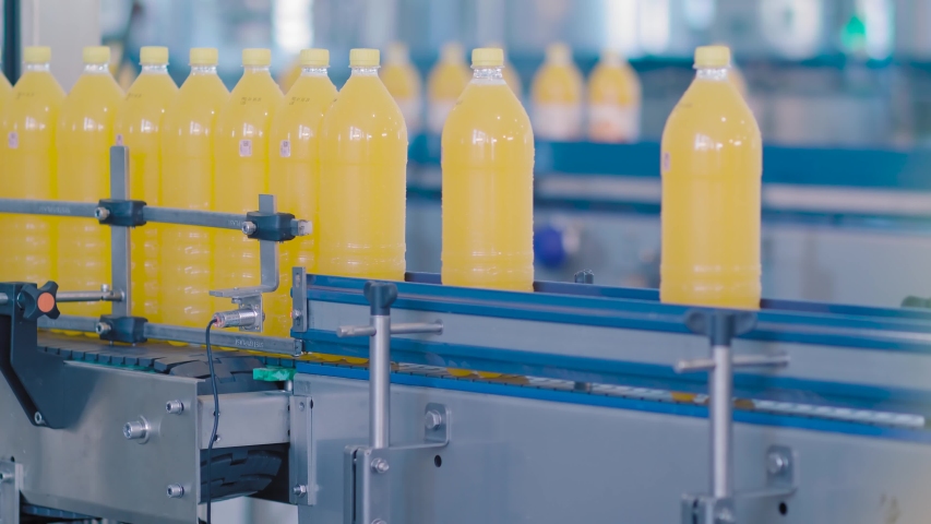 Bottles filled with juice are moving along the conveyor Royalty-Free Stock Footage #1054410833