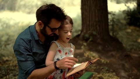 Single Parent Dad Teach Adorable Cute Preschool Child Girl.Cheerful Daughter Education Learn 
Read Book And Enjoying Family Lifestyle.Little Kid With Father Reading Book.Daddy Reading Fairy Tale Story