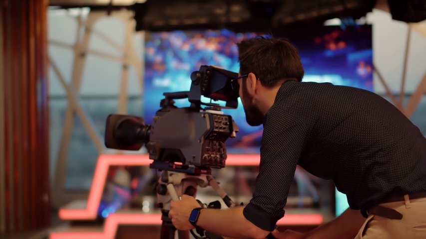 Television Operator On TV Broadcasting Production Channel. Camera Operator On News Room Shoot Media Movie. Making TV Show Or Film. Cameraman Working In TV Studio Video Production Filming Interview Royalty-Free Stock Footage #1054414451