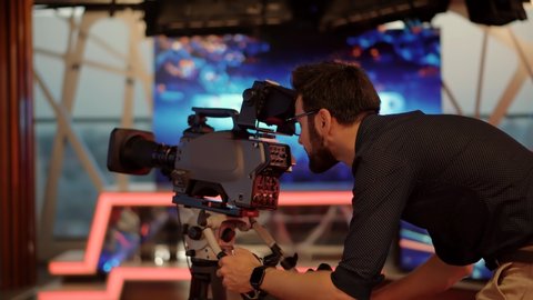 Television Operator On TV Broadcasting Production Channel. Camera Operator On News Room Shoot Media Movie. Making TV Show Or Film. Cameraman Working In TV Studio Video Production Filming Interview