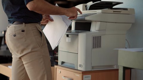 Man Using Printer Or Scanner In Office.Businessman Printing Document On Workplace.Man Finger Press Buttons On Multifunctional Copier.Businessman Working In Office And Preparing Documents For Signature