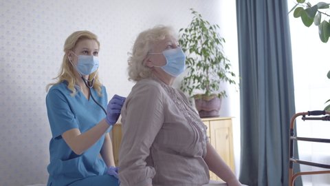 Woman doctor examining contagious patient in protective mask, healthcare