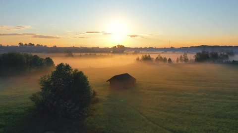 Fog morning over the plain and river floodplain of the meadow near a rural village with a house, aerial view landscape