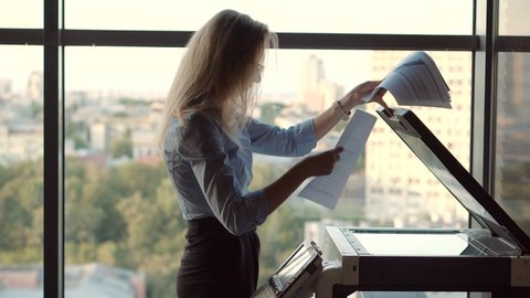 Woman Preparing Financial Audit Report For Marketing Strategy.Businesswoman Using Printer In Office.Girl Using Copier For Replicate Paperwork. Secretary Girl Sending Fax On Email And Printing Document