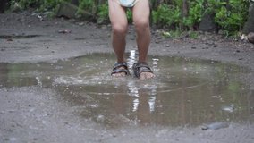 4K Video of Asian Filipino Kid Feet Playing and Jumping in the Puddle of Mud while Raining in a Poor Rural Village in the Philippines