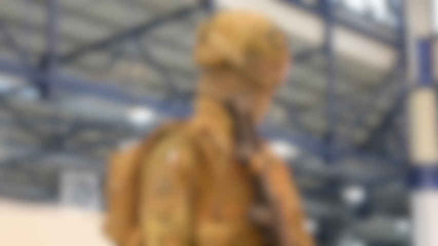 Blurred background. Mannequin dressed various body armor and protective helmets. Example military uniform outfit.