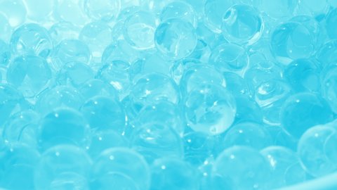 Glass balls of bluish glass. Smooth rotation. Hydrogel and beads. Macro video