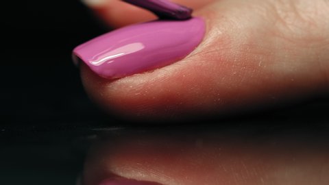 manicurist applying purple nail polish. manicure process. Application of nail polish on nails.