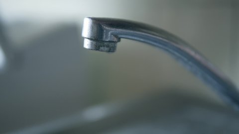 Faucet water slow motion. Water drop waste. Kitchen sink