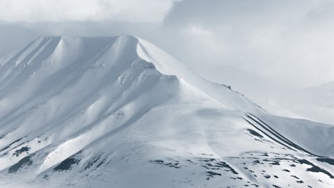 The Arctic region of Svalbard, mountains and valleys covered with snow and low cloud
