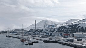 Longyearbyen town harbour docks and buildings, waterfront with boats moored.