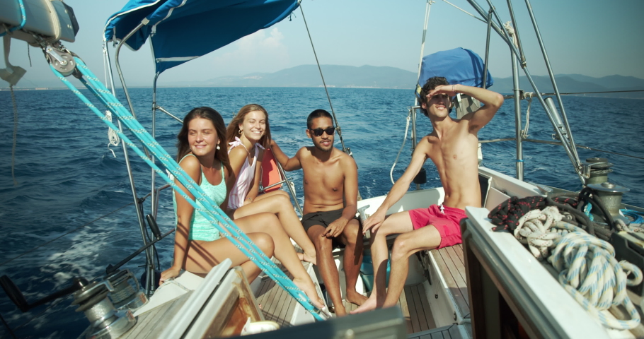 Group of young friends enjoying trip on a sailboat in the Ligurian Sea.