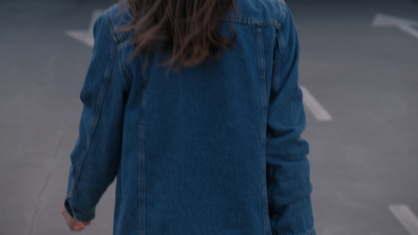 Rear Back View Of Girl Going Forward. The Girl Wearing Jean Jacket and Black Jeans. Summer Evening Royalty-Free Stock Footage #1054444328