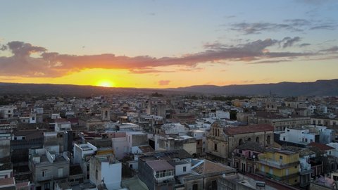 Drone flies over the small sicilian town Floridia at sunset, province of Siracusa in Sicily