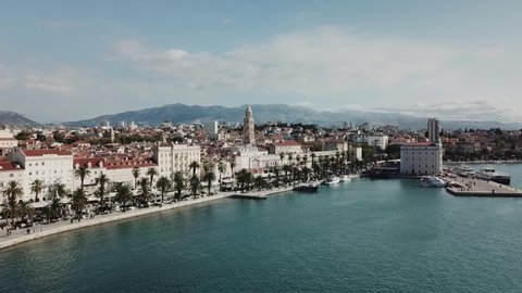 Moving away drone shot, showing ancient roman town, blue sea and mountains in Split, Croatia.