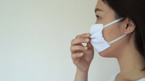 Footage showing a portrait of woman mask on a face mask or protective mask over her face, protecting herself from coronavirus, COVID-19 virus with copyspace. COVID19 outbreak and healthcare concept