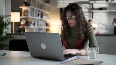 Young Business Woman Professional Entrepreneur Using Laptop Computer Notebook At Workplace Typing Email Making Notes Sitting At Desk Working Doing Online Job In Modern Office