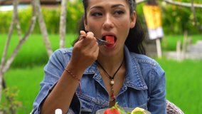 Young, beautiful asian woman eating fruit salad sitting in cafe - Powered by Shutterstock - Get 15% off with code: PIKWIZARD15