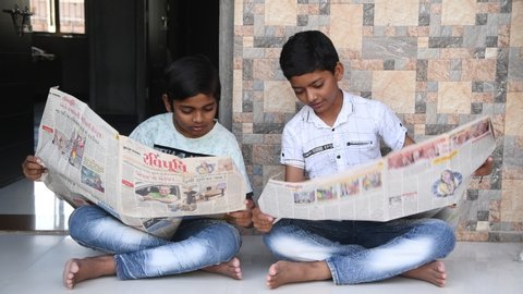  14 MAY 2020, MORBI,INDIA:- little 10 years old kids reading Indian news paper at home. Reading news paper during corona virus (covid19). Boys shocked during read corona virus news. 