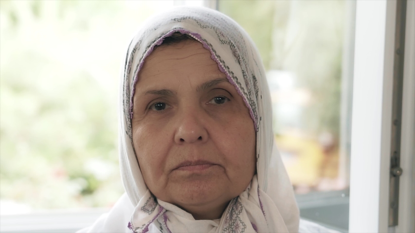 An old Muslim woman portrait. Cheerful hijab Islamic Turkish mother is smiling. S3niorLife | Shutterstock HD Video #1054475453