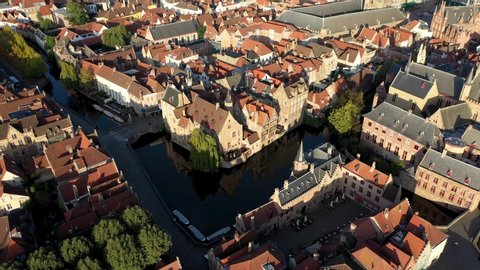Aerial view from the historic center of Bruges with a pan up reveal of the Belfry bell tower and market square