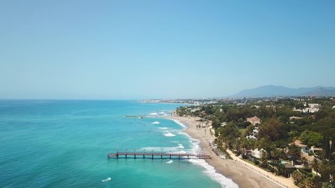 Puente Romano bridge in exclusive area of Marbella. Golden mile view of Nagueles Beach. Drone going forward , near the wood bridge. Empty location due corona virus pandemic, normally full of tourists