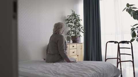 Disabled old woman sitting in room alone, taking medicines, lonely at senior age