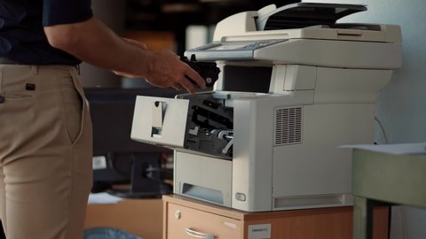 Employee Working In Office.IT Support Copier Maintenance In Office Removing And Changing Toner Tube. Man From Helpdesk Replace Cartridge In Printer. Hand Swapping Cartridge On Multifunctional Printer