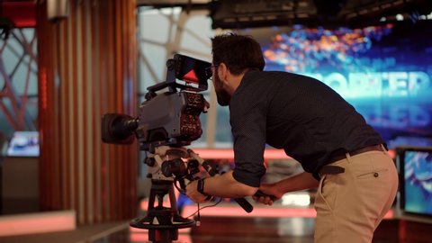 Making TV Show Or Film. Television Operator On TV Broadcasting Production Channel. Camera Operator On News Room Shoot Media Movie. Cameraman Working In TV Studio Video Production Filming Interview