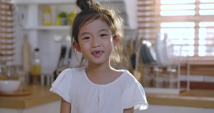 Close up portrait of Young asian little girl smiling with a toothless smile. Show no teeth. | Shutterstock HD Video #1054493306