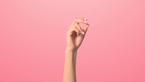 Click your fingers to change the background color. Pink background, a woman's hand rises making a finger click and changes color