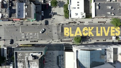 NEW YORK - JUNE 16, 2020: Black Lives Matter painted huge on street - BLM yellow paint - high aerial view over Fulton st. in Bed-Stuy, Brooklyn, NYC.
