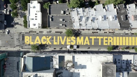 NEW YORK - JUNE 16, 2020: Black Lives Matter - BLM huge words in big yellow paint - aerial view on Fulton Street in Bed-Stuy, Brooklyn, NYC.