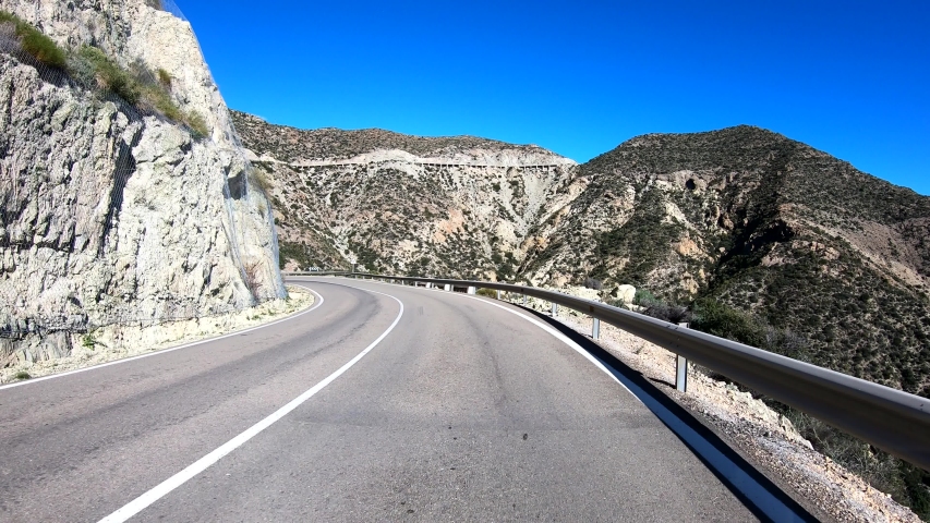 Go Pro drive spanish mountain descent. Windy dangerous roads, clear sky  Royalty-Free Stock Footage #1054510472