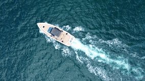 Aerial drone tracking video of powerboat cruising in low speed in deep blue Aegean sea