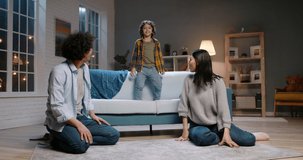 Funny asian family relaxing at home together. Little kid with curly hair jumping onto his father, doing a piggy back ride and laughing - happy family, recreational pursuit 4k footage