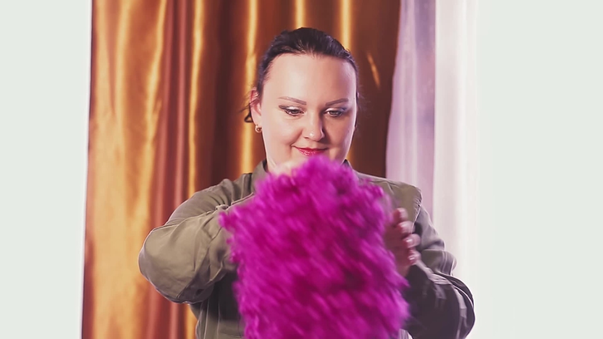 A young woman is dancing in a carnival wig with purple curls