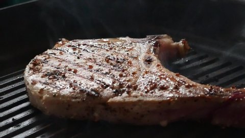 Grilled pork Steak T-bone in frying pan.