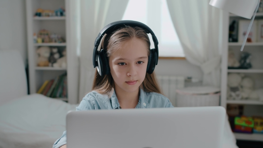 Beautiful girl student in headphone study online with internet teacher learn looking at laptop, distance education concept slow motion | Shutterstock HD Video #1054523927