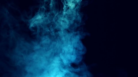 Streams of smoke from top to bottom in the dark and forms a beautiful swirl on a black background. Closeup. The camera moves around. Slow motion. High speed camera